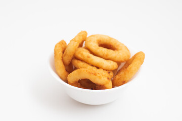 Portion of fried onion rings in a white bowl isolated on a white background