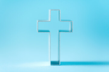 Obraz premium Christian cross on blue background with soft bokeh lights background. Copy space. Banner. Church worship, salvation concept. Faith symbol in Jesus Christ. Holy cross for good friday, Easter day