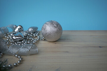 The silver ball and other Christmas decorations on a wooden background with a blue background