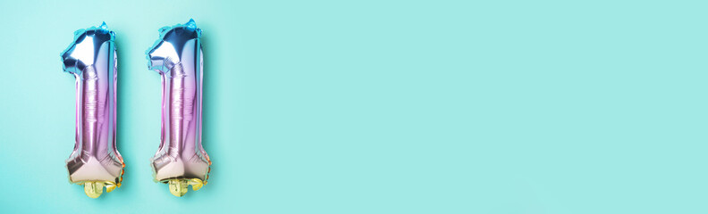 Creative layout. Rainbow foil balloon number, digit eleven. Birthday greeting card with inscription...