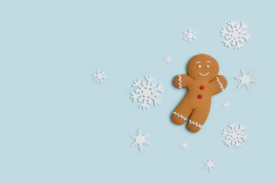 Classic gingerbread cookie hero isolated on blue with decorative showflakes