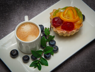 cup of coffee, pastry and berries of bow whortleberry