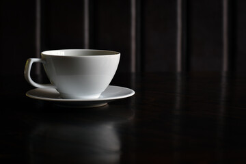Shadow background, White coffee cup on wooden table with copy space.