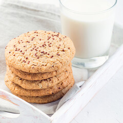 Healthy oatmeal and red quinoa cookies on a white tray, served with milk, closeup, squaree