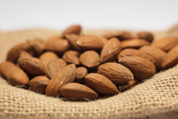 almonds with raffia sack, white background