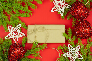 Christmas composition. Gifts, spruce branches, red shiny decorations on a red background. 