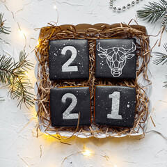 New Year's gingerbread with the numbers 2021 and the image of a bull - the symbol of the Chinese New Year.
White background, black numbers. Minimalism.
