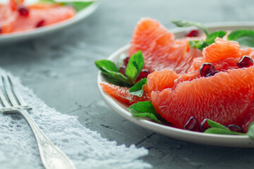 Grapefruit slices with mint leaves, sprinkled with pomegranate.