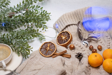 Obraz na płótnie Canvas Medical mask and accessories for the New Year, green twig, dry oranges, Czech woman with coffee, Christmas tree garland, woolen sweater. Flatley on white background. Concept of congratulation merry ch