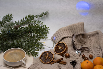 Fototapeta na wymiar Medical mask and accessories for the New Year, green twig, dry oranges, Czech woman with coffee, Christmas tree garland, woolen sweater. Flatley on white background. Concept of congratulation merry ch