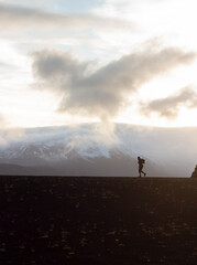 Fototapeta premium Silhouette of a person hiking in the mountains of Iceland on a bright day