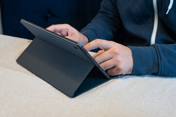 a man is typing something on a tablet pc