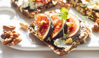 Fig, cheese, honey, walnut toast with hard shadow