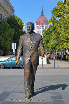 Statue Of The Former U.S. President Ronald Reagan On The Background Of Hungarian Parliament Building In Budapest, Hungary