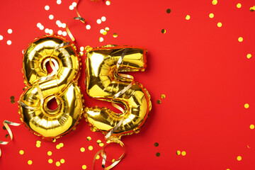Gold foil balloon number, digit eighty-five. Birthday greeting card with inscription 85. Anniversary celebration event. Banner. Golden numeral, red background. Numerical digit, bright shiny glitter