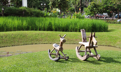 Fototapeta premium Closeup of traditional wooden toy chairs on green lawn. 