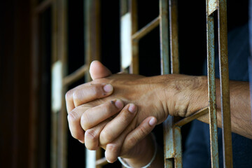 close up of prisoner hands in jail