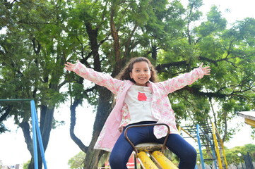 Niña feliz jugando en el parque en primavera