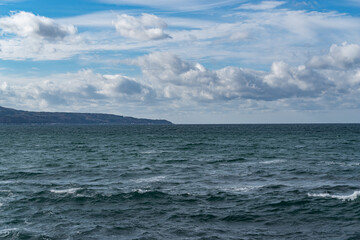 Fototapeta na wymiar 白波が打ち付ける青空の海岸と地平線