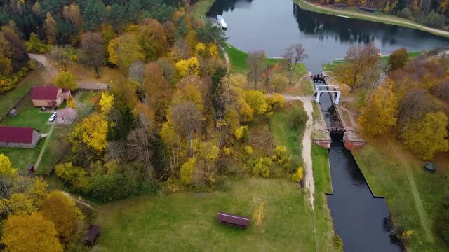 Wonderful autumn colors: Drone shot of a river  leading through a colorful forest at fall. by a drone,  while flight smooth. Augustow Canal.