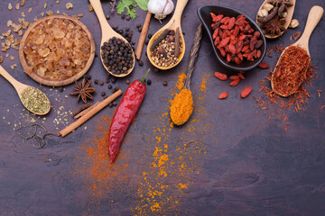 Spoon of assorted spices chili garlic salt kosher pepper paste on stone table top view with copy space.