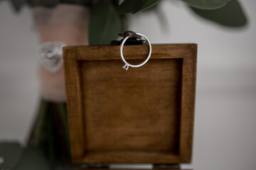 engagement ring hanging on a wooden ring box