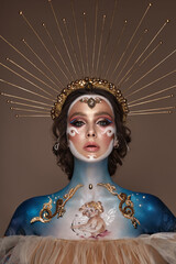 Portrait of a girl with gold and blue creative art make-up.