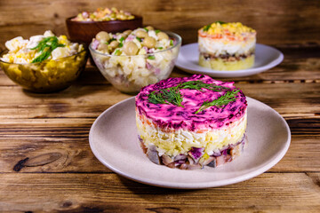 Set of festive mayonnaise salads on wooden table