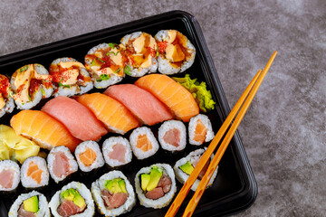 Assortment of sushi roll set on a black tray. Japanese food.