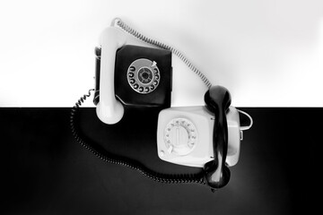two vintage telephone sets with dial in retro style on a black, white background, concept of old...