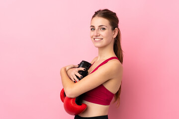 Young sport woman over isolated pink background with boxing gloves