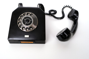 vintage black telephone set with dialing dial in retro style on white background, concept of old...