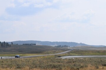 Fototapeta na wymiar Yellowstone National Park Road Meadow Field Montain Scene View