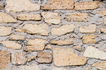 stone wall masonry rakushnyaka sealed with cement mortar, wall texture, the background