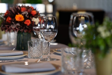 An empty glass for wine on a table of a cafe or restaurant served for several guests. Shallow depth of field, blurred background