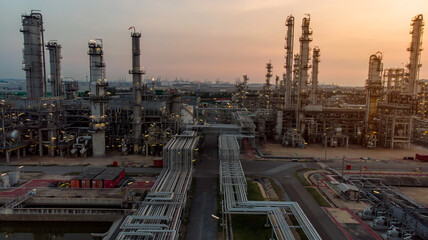 Aerial view of pipe and chemical oil refinery plant, power plant and metal pipe on sunset sky background.