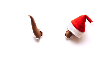 Two brown bull horns break through the white background.On one horn is a Santa Claus hat.Bull as a symbol of the New year 2021.Creative New Year and Christmas concept, copy space for text.