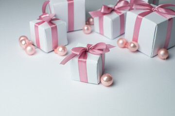 White gifts with pink ribbons. Set of gift box isolated on white background.Christmas gift boxes on white background. Beautiful Christmas background with shiny balls and ribbons in pastel pink color. 
