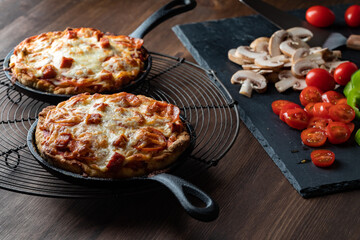 Two homemade individual pan pizzas fresh out of the oven ready for eating.