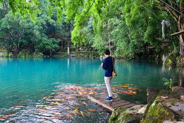 a man feeds fish in the lake