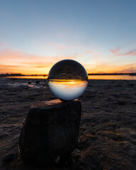 Beautiful sunset captured through a lens ball at the coastline