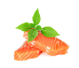Piece of fresh salmon fillet sliced with leaf basil isolated on white background