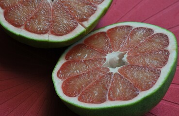 A close up of the surface of the red pomelo petals on the red colour  background , Red pomelo , cut into half , Texture of pomelo meat