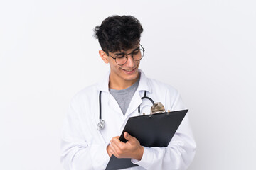 Young Argentinian man over isolated white background wearing a doctor gown and holding a folder