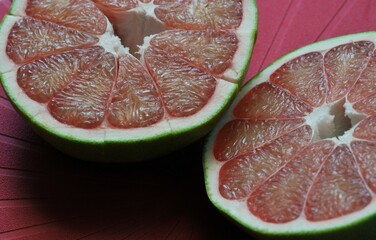 A close up of the surface of the red pomelo petals on the red colour  background , Red pomelo , cut...