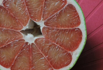 A close up of the surface of the red pomelo petals on the red colour  background , Red pomelo , cut into half , Texture of pomelo meat