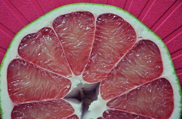 A close up of the surface of the red pomelo petals on the red colour  background , Red pomelo , cut into half , Texture of pomelo meat