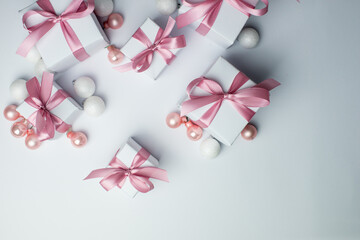 White gifts with pink ribbons. Set of gift box isolated on white background.Christmas gift boxes on white background. Beautiful Christmas background with shiny balls and ribbons in pastel pink color. 