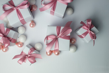 White gifts with pink ribbons. Set of gift box isolated on white background.Christmas gift boxes on white background. Beautiful Christmas background with shiny balls and ribbons in pastel pink color. 