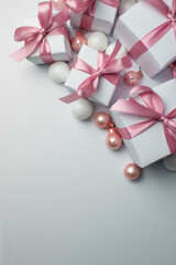 White gifts with pink ribbons. Set of gift box isolated on white background.Christmas gift boxes on white background. Beautiful Christmas background with shiny balls and ribbons in pastel pink color. 